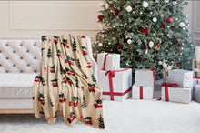 Load image into Gallery viewer, Beige blanket with Christmas tree pattern draped over a couch in front of a decorated Christmas tree and presents.
